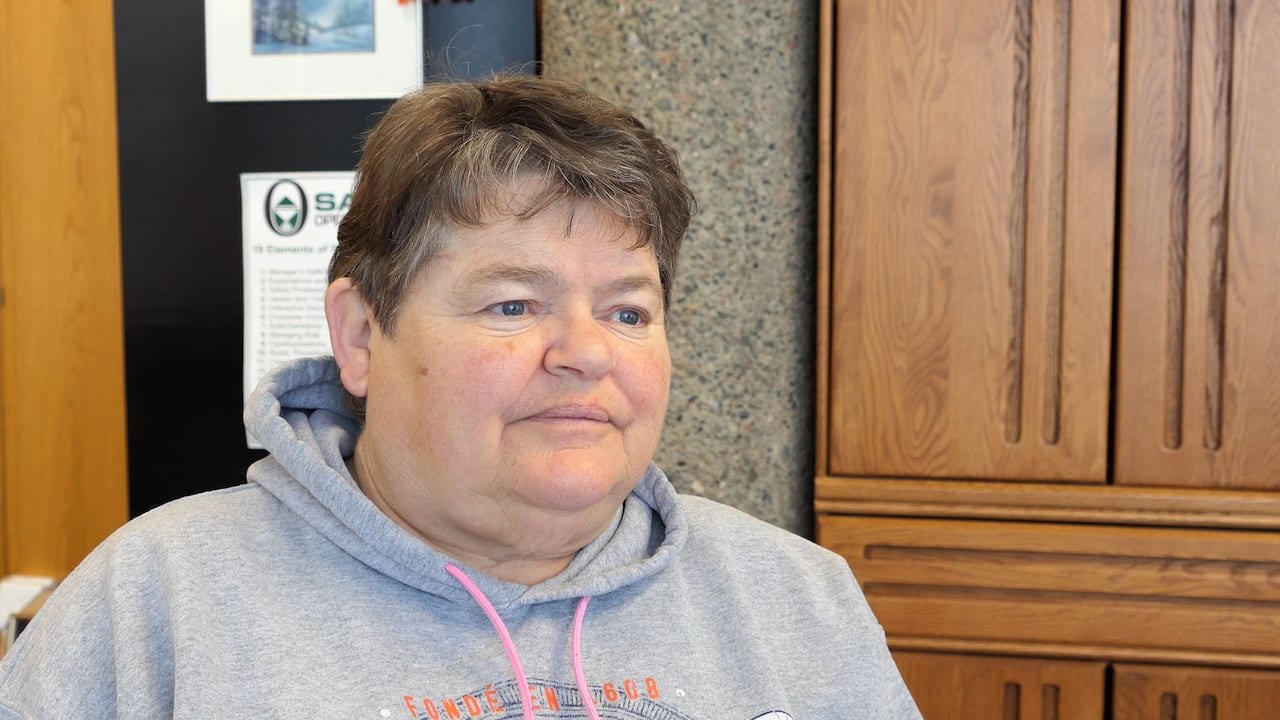 A woman in a grey hoodie with pink strings.